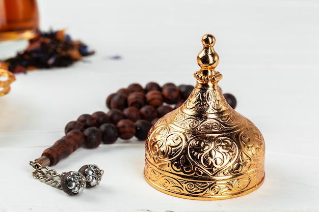 Une tasse de thé avec des perles de prière islamiques en gros plan