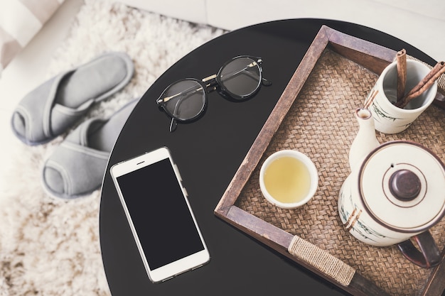 tasse de thé sur un plateau en bois sur une table ronde avec canapé dans le salon