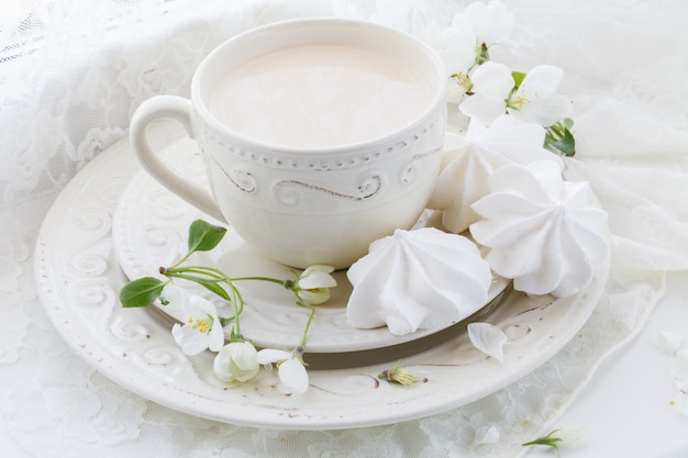 Tasse de thé en porcelaine avec du lait sur le mur blanc