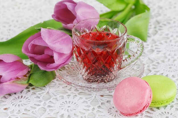 Tasse de thé rouge karkadeh avec macarons et tulipes