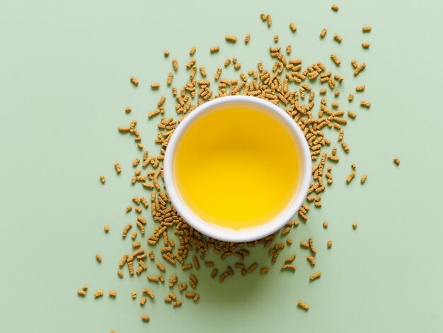 tasse de thé de sarrasin sur un fond vert clair Vue supérieure du thé de soba sain sur des grains sur un fond de papier vert