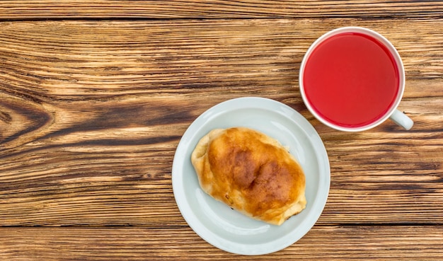 Tasse de thé et soucoupe avec brioche sucrée sur la table Vue de dessus