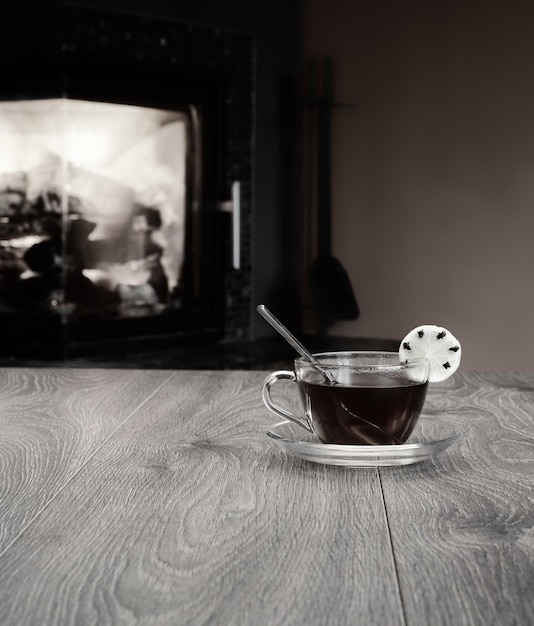 Tasse de thé sur table sur fond de feu dans la cheminée