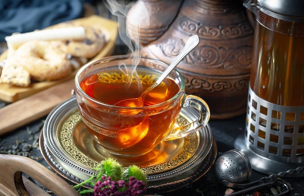 Une tasse de thé avec une tasse de thé sur une table à côté d'une théière.