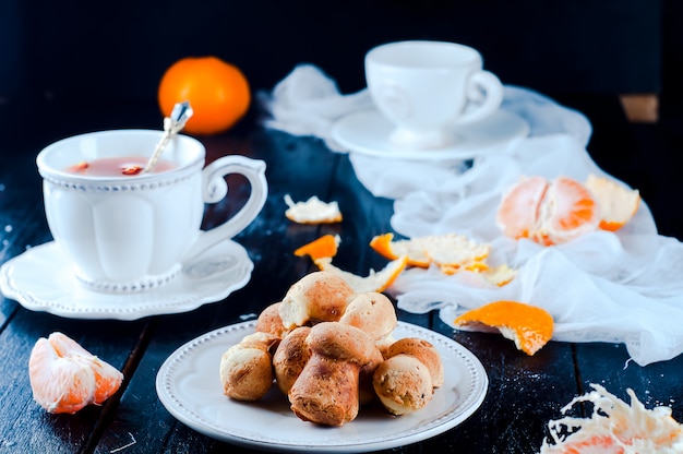 tasse à thé avec thé et biscuits ange, mandarine sur un tableau noir