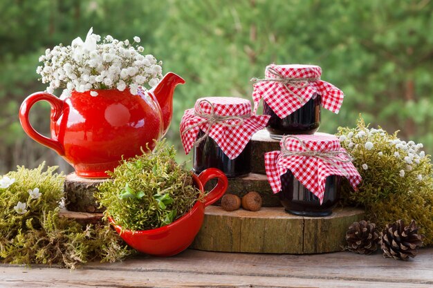 Tasse à thé théière rouge et bocaux de confiture saine Forêt sur fond