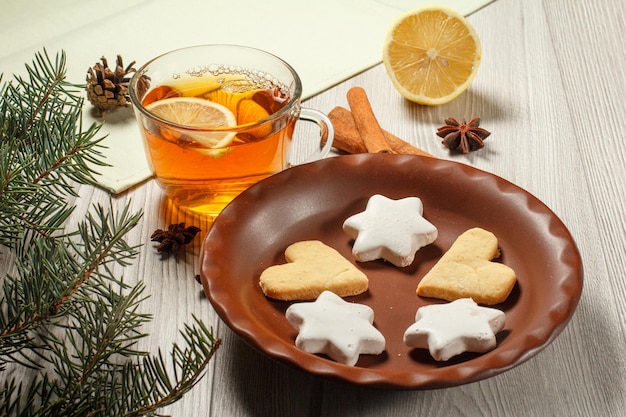 Tasse de thé avec tranche de biscuits au pain d'épice au citron et branche de sapin