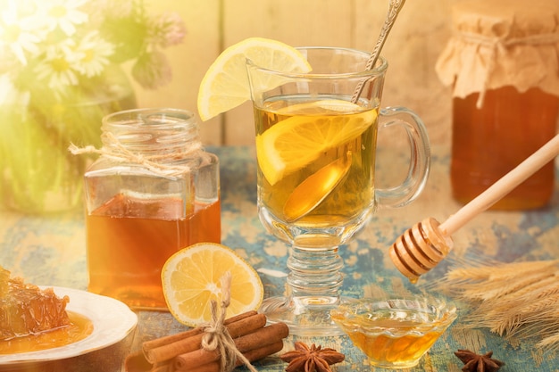 Une tasse de thé en verre avec du citron et du miel sur la table