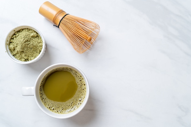 tasse de thé vert matcha chaud avec poudre de thé vert et fouet