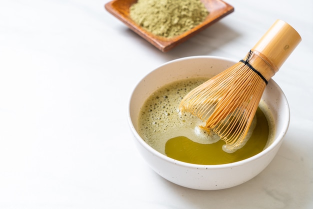 tasse de thé vert matcha chaud avec poudre de thé vert et fouet