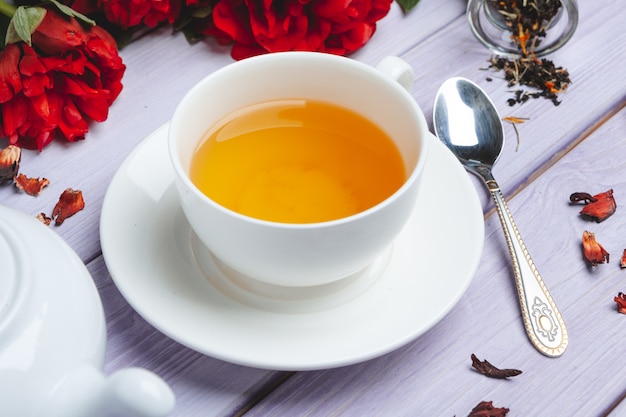 Tasse de thé vert sur la table avec des fleurs de pivoine fraîche