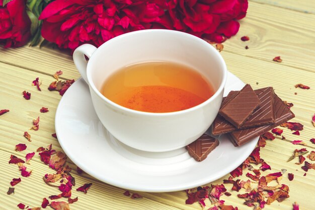 Tasse de thé vert sur la table avec des fleurs de pivoine fraîche