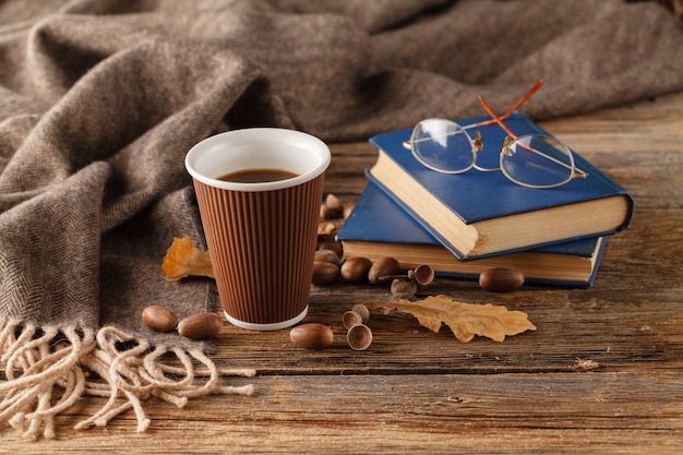 Tasse de thé avec vieux livre, feuilles d'automne sur table en bois