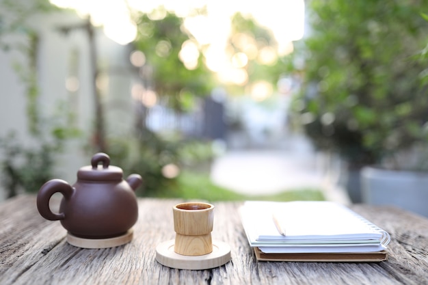 Tasse et théière en bambou avec cahiers sur table en bois