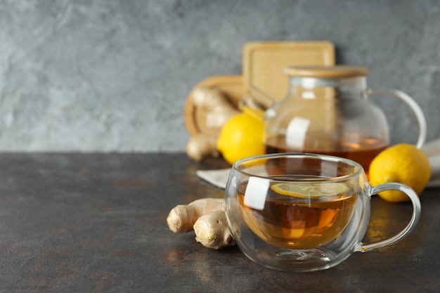 Tasse et théière avec thé citron et gingembre sur fond gris espace pour le texte