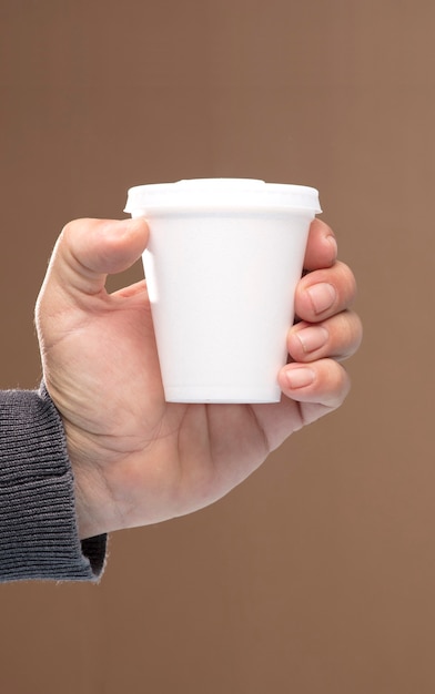 tasse thermique dans les mains de l'homme contenant jetable