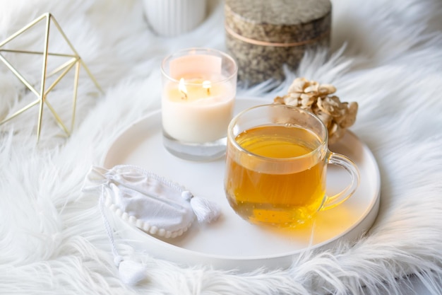 Tasse De Tisane Et Bougie Allumée Sur Plateau Décoratif Blanc Rond