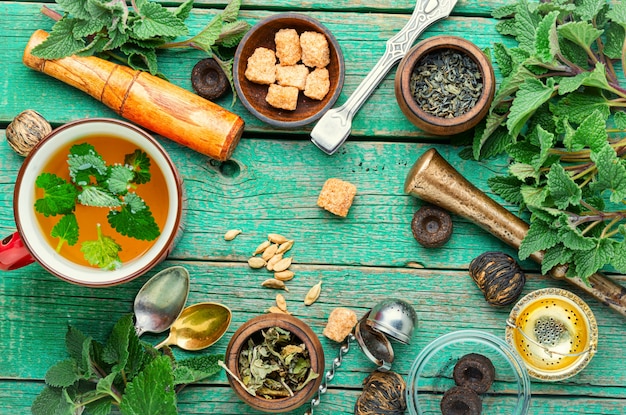 Tasse de tisane fraîche avec mélisse sur table en bois. Ingrédients de la tisane