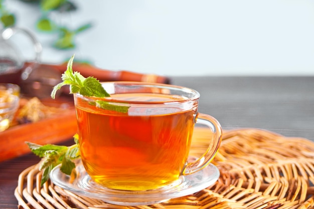 Tasse de tisane à la menthe avec des herbes sèches sur le plateau