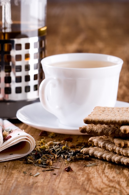 Tasse de tisane et quelques biscuits frais agrandi sur une table en bois