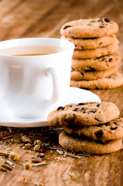 Tasse de tisane et quelques biscuits frais agrandi sur une table en bois