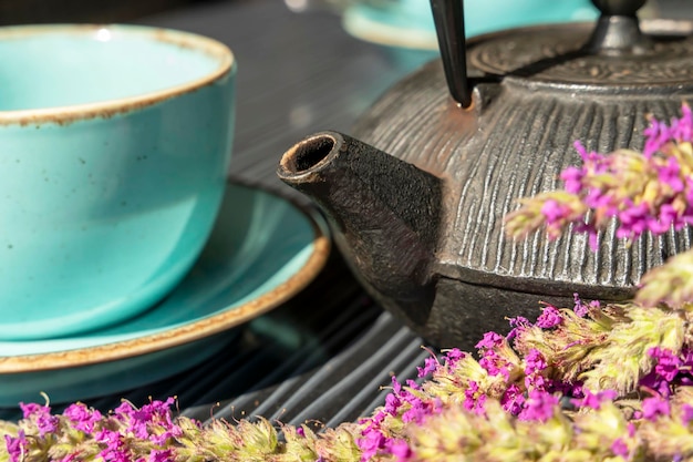 Tasse turquoise de thé chaud et une petite théière sur une table dans un café