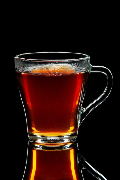 Tasse en verre de thé noir sur un tableau noir