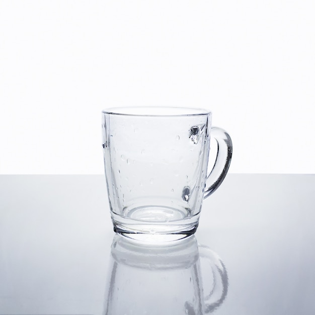 Tasse en verre transparent vide avec des gouttes d'eau.