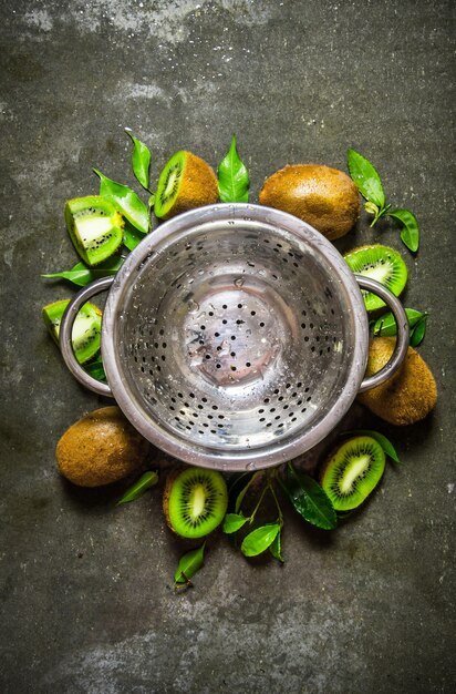 Tasse vide avec kiwi et feuilles autour.