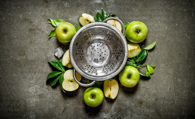 Tasse vide et pommes vertes avec des feuilles. Sur une table en pierre rustique. Vue de dessus