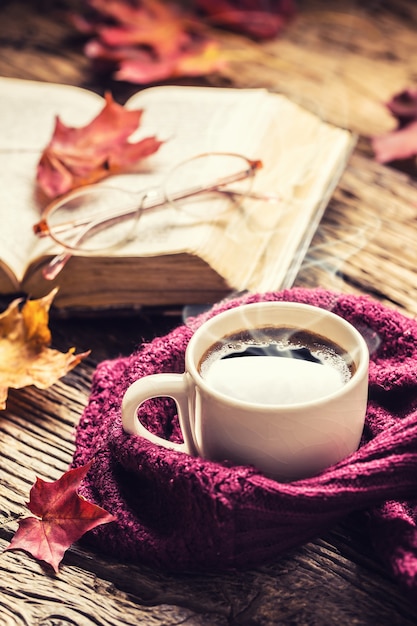 Tasse de vieux verres à café et feuilles d'automne sur une table en bois rustique.