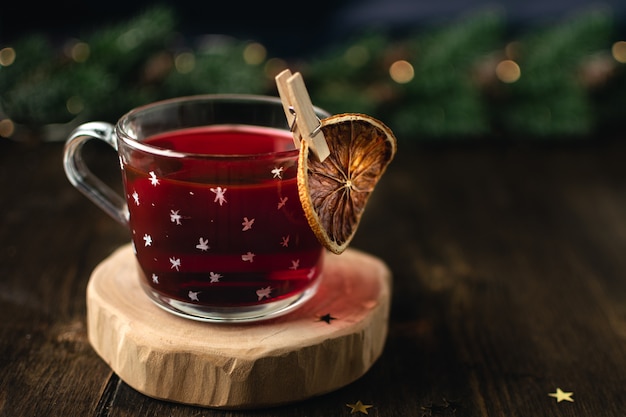 Tasse de vin chaud dans une tasse transparente, orange séchée, bâton de cannelle, anis étoilé