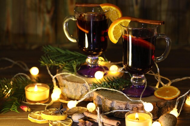 Tasse de vin chaud avec décoration et bougies sur fond de bois foncé