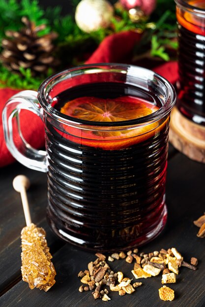 Une tasse de vin chaud sur un fond en bois foncé