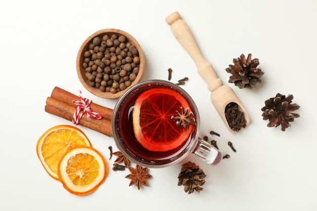 Tasse de vin chaud et ingrédients sur fond blanc