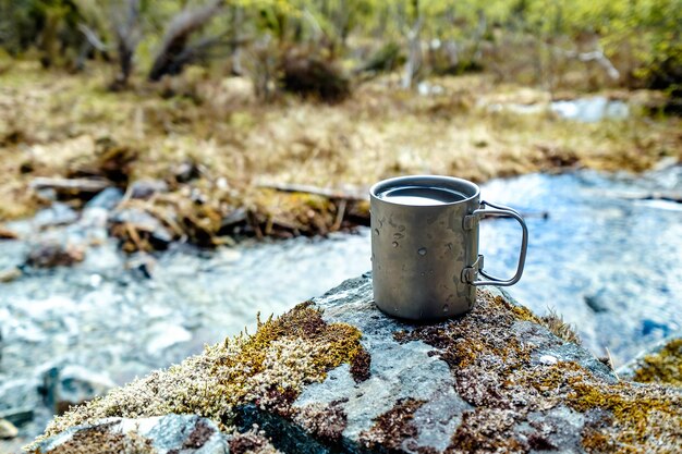 Tasse de voyage en titane. Déjeuner pendant le voyage dans la nature. Mode de vie au camping.