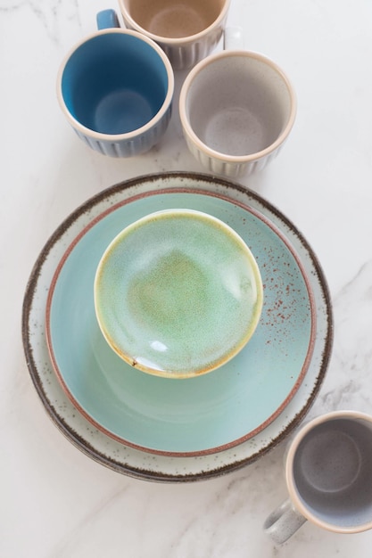 Tasses et assiettes en céramique sur table en marbre blanc