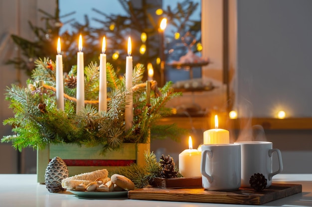 Tasses blanches avec boisson chaude et décorations de Noël à la maison