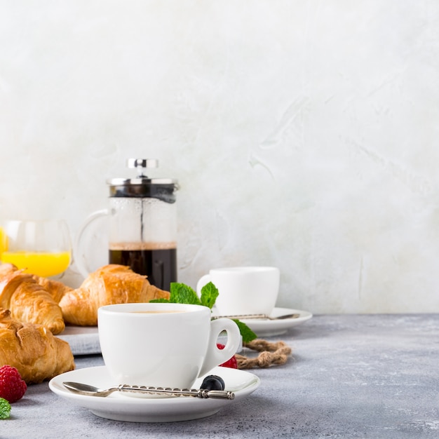 Tasses blanches de café et de croissants