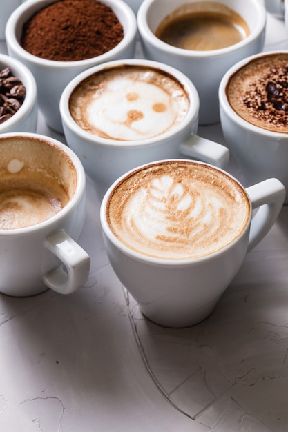 Tasses blanches de différentes étapes de préparation du cappuccino. Concept d'amateur de café nature morte