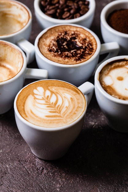 Tasses blanches de différentes étapes de préparation du cappuccino. Concept d'amateur de café nature morte