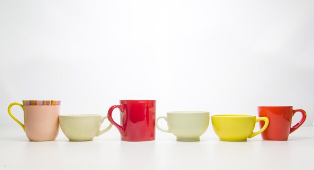 Photo des tasses de café colorées sur fond blanc