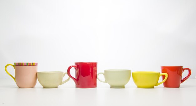 Des tasses de café colorées sur fond blanc