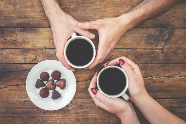 Tasses avec un café dans les mains des hommes et des femmes. Mise au point sélective.