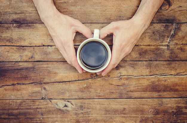 Tasses avec un café dans les mains des hommes et des femmes. Mise au point sélective.