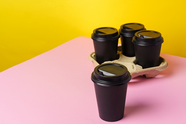 Tasses à café à emporter noires dans le support