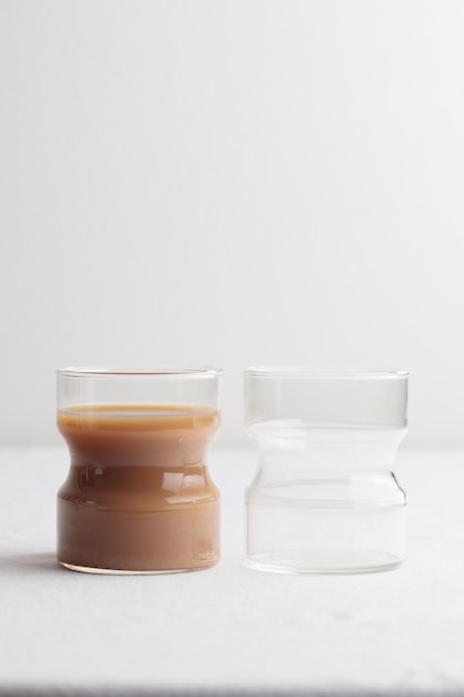 Tasses de café frais avec du lait sur tableau blanc