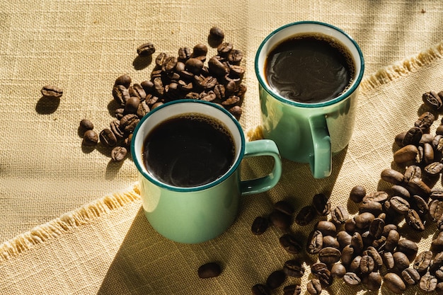 Tasses de café et de grains de café illuminés par la lumière du soleil jour d'automne