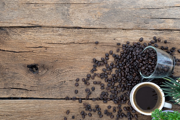 Des tasses à café et des grains de café sont sur le bureau