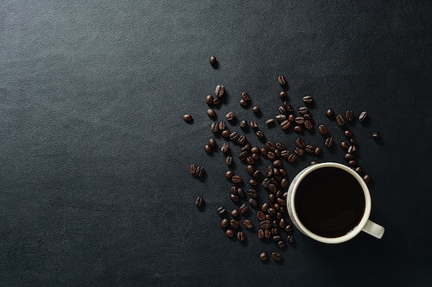 Des tasses à café et des grains de café sont sur le bureau